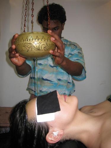 a man is holding a bowl on a swing at Muthumuni Ayurveda Beach Resort in Beruwala