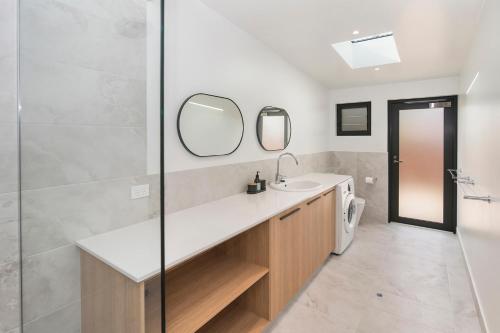 ein Bad mit einem Waschbecken und einem Spiegel in der Unterkunft FortyTwo Mini in Gracetown