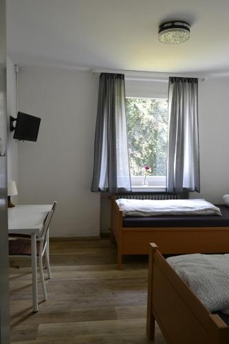 a bedroom with a bed and a window at Pension Highway 3 in Bielefeld