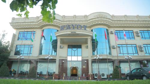 タシュケントにあるHayot Hotelの旗の目の前の大きな建物