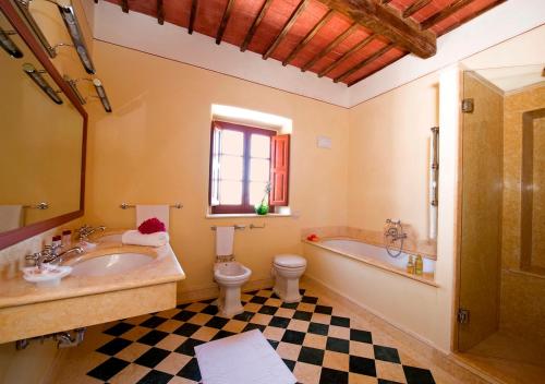 a bathroom with a sink and a tub and a toilet at Castello Di Gargonza in Monte San Savino