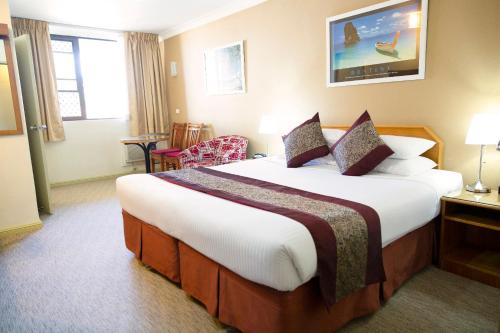 a bedroom with a large bed in a hotel room at Ryde Inn in Sydney