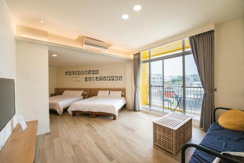 a bedroom with two beds and a balcony at Little Turkey B&B in Xiaoliuqiu