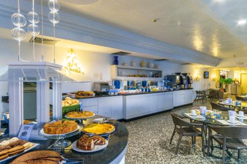 una línea de buffet con muchos platos de comida en las mesas en Hotel Panoramic, en Caorle
