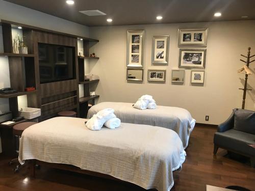 two beds with towels on them in a room at Hotel Mystays Premier Akasaka in Tokyo