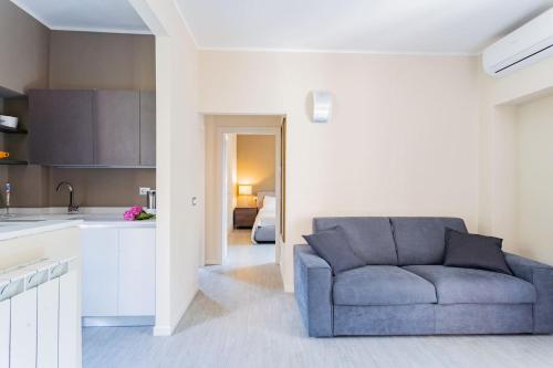 a living room with a blue couch and a kitchen at Amazing Cernobbio - Lake Como by Rent All Como in Cernobbio