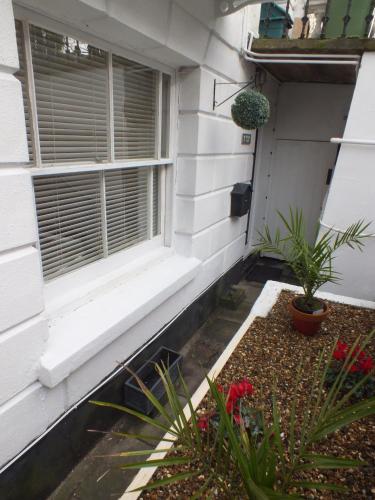 a window on the side of a house with plants at Garden Flat in Royal Tunbridge Wells