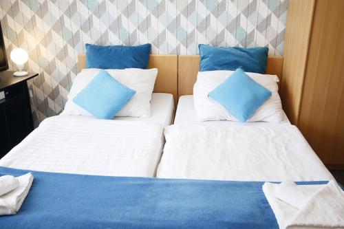 two beds in a room with blue and white pillows at Willa Scandia in Duszniki Zdrój