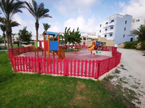 a playground in a park with a red fence at King Alexander Villa 22 in Paphos