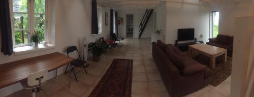a living room with a couch and a table at Happy Hill Farm in Gilleleje