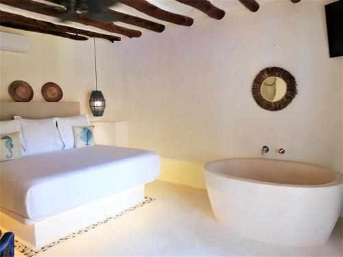 a bathroom with a tub and a bed at Soho Boutique Holbox - Adults Only in Holbox Island