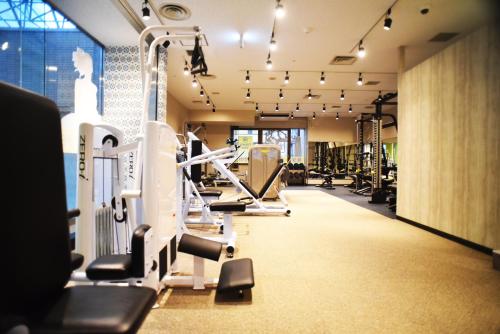a gym with treadmills and machines in a room at Hotel Agora Osaka Moriguchi in Osaka