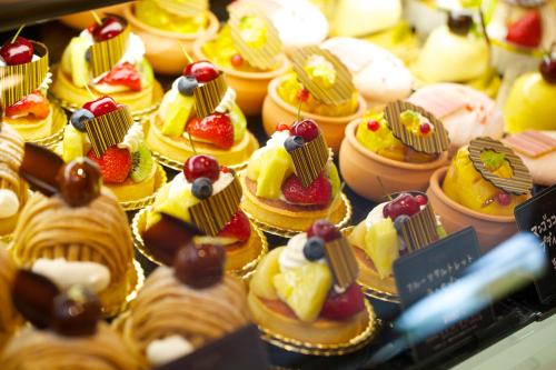 a bunch of cakes and pastries in a display case at Hotel Agora Osaka Moriguchi in Osaka