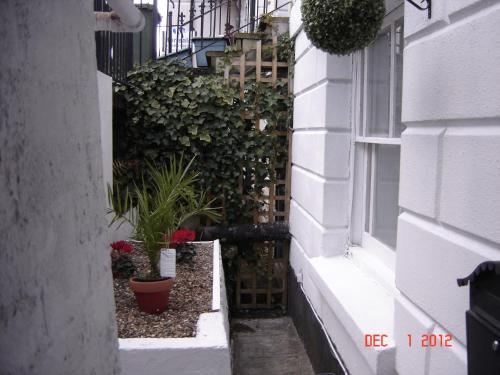 a small alley with plants and a window at Garden Flat in Royal Tunbridge Wells