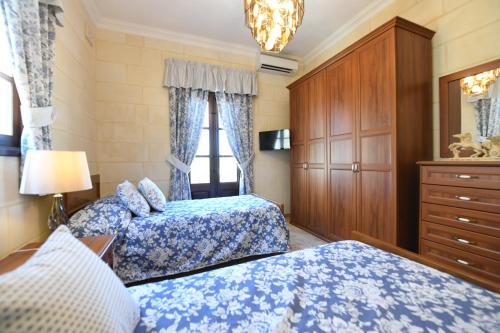 a bedroom with two beds and a dresser at Ir- Razzett t'Indri in Qala