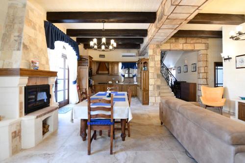 a living room with a table and a couch at Ir- Razzett t'Indri in Qala