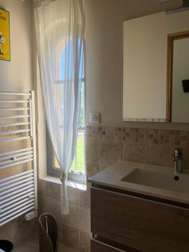 eine Küche mit einem Waschbecken und einem Fenster in der Unterkunft le Mas des Pignes -adults only in Aix-en-Provence