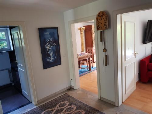a hallway with a room with a red couch and a painting on the wall at Ferienwohnung im Gartenparadies in Eurasburg