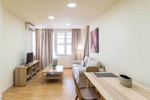 ein Wohnzimmer mit einem Sofa und einem Tisch in der Unterkunft Athens Kyniska Urban Apartment in Athen