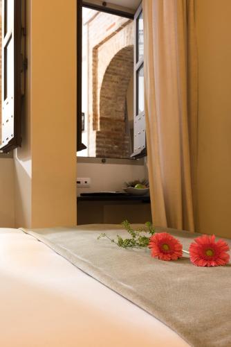 two flowers sitting on a bed in a bedroom at Balcón de Córdoba in Córdoba