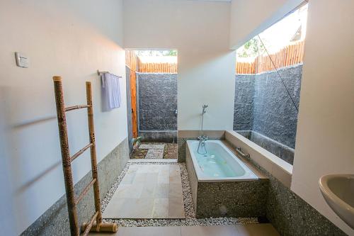 La salle de bains est pourvue d'une baignoire et d'un lavabo. dans l'établissement Ambengan Private Villas, à Nusa Penida