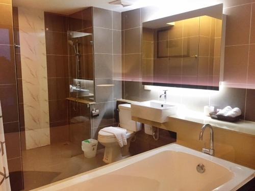 彭世洛的住宿－和諧城市酒店，带浴缸、盥洗盆和卫生间的浴室