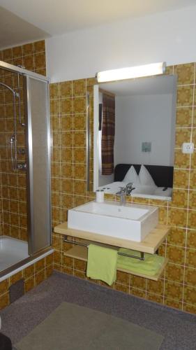 ザールバッハ・ヒンターグレムにあるPanoramaの洗面台、鏡、浴槽のあるバスルーム