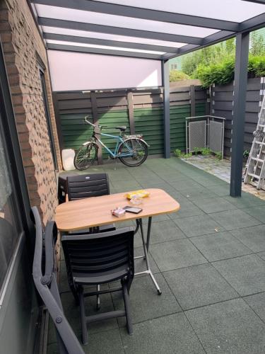 einen Tisch und Stühle auf einer Terrasse mit einem Fahrrad in der Unterkunft Hababa Short Stay in Amsterdam