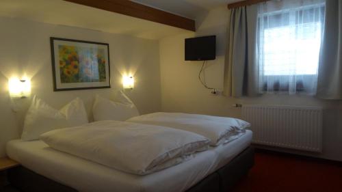 ザールバッハ・ヒンターグレムにあるPanoramaの白いシーツと窓のあるベッドのある寝室