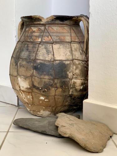 a vase sitting on the floor next to a wall at Gyöngyszem Vendégház in Eger