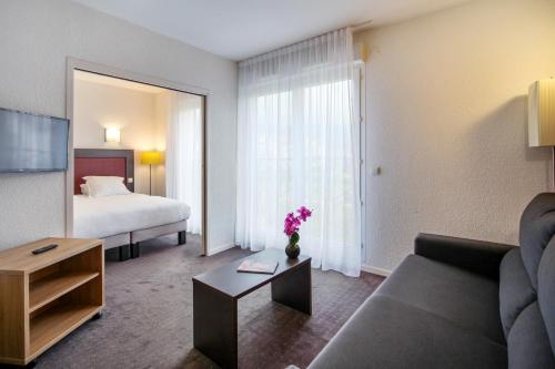 Un pat sau paturi într-o cameră la Zenitude Hôtel-Résidences Divonne Confort