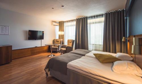 a hotel room with a bed and a flat screen tv at Hotelli Seurahovi in Porvoo