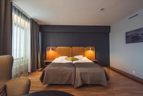 ポルヴォーにあるHotelli Seurahoviのベッドルーム1室(大型ベッド1台、ランプ2つ付)