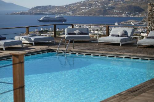 una piscina en una terraza con un crucero en Tharroe of Mykonos Boutique Hotel, en Mykonos ciudad