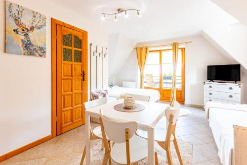 a living room with a white table and chairs at Willa Natura in Gliczarów