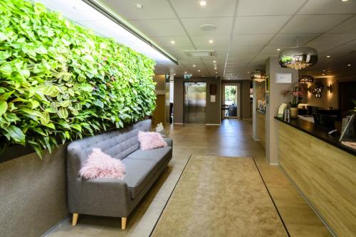 a lobby with a couch and a green wall at The Hotel Unforgettable - Hotel Tiliana by Homoky Hotels & Spa in Budapest
