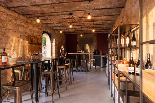 un bar con mesas y taburetes en un edificio en Château de Tauzies, The Originals Relais en Gaillac