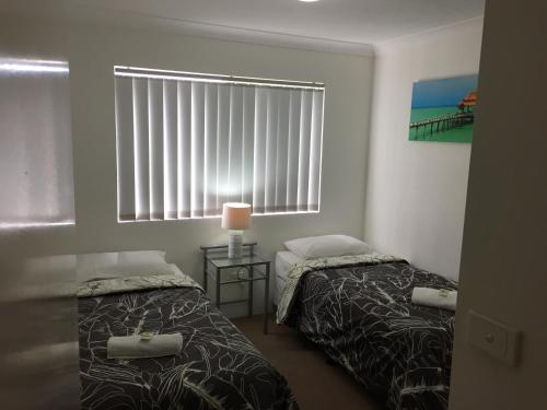 a bedroom with two beds and a window at Bayview Waters Apartments in Gold Coast
