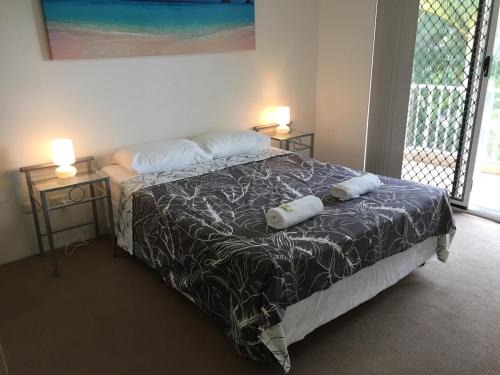 een slaapkamer met een bed met 2 kussens erop bij Bayview Waters Apartments in Gold Coast