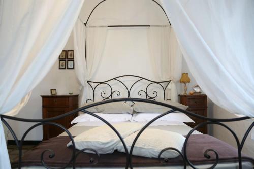 Schlafzimmer mit Himmelbett und weißen Vorhängen in der Unterkunft Ca' di Ro in Camogli