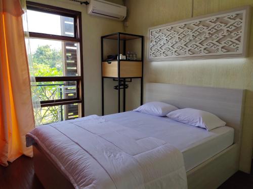 De Hanami Homestay @Sapphire في تْشيريبون: غرفة نوم بسرير ابيض ونافذة