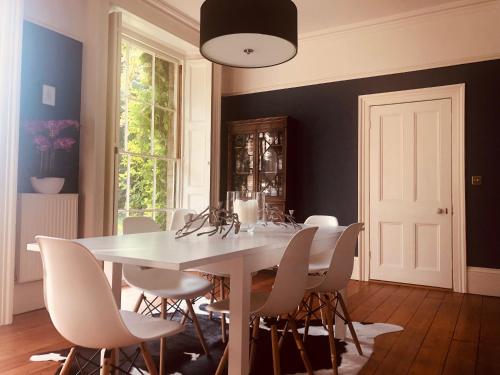 a dining room with a white table and chairs at Somerleyton Meadows - The Hideaway Hut & Hot Tub in Herringfleet
