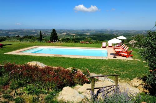 a swimming pool in a yard with two lawn chairs at Casa Vacanze Podere Casacce in San Casciano in Val di Pesa
