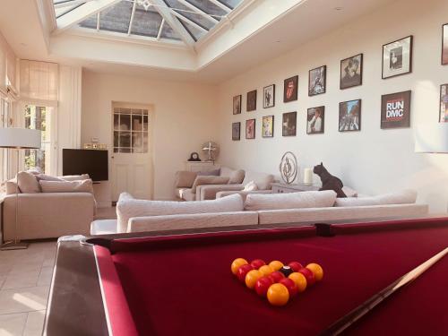 a living room with a pool table in the middle at Somerleyton Meadows - The Hideaway Hut & Hot Tub in Herringfleet