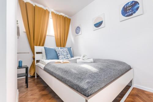Apartaments Solec 79 by Renters في وارسو: غرفة نوم صغيرة بسرير من اللون الأزرق والأبيض
