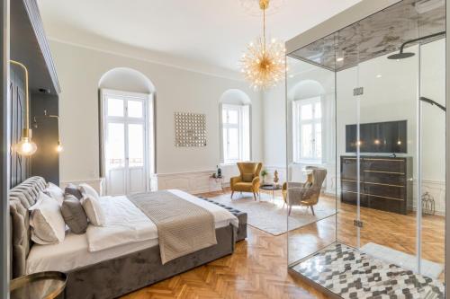 a bedroom with a king sized bed and a living room at Mid City Apartments in Cluj-Napoca