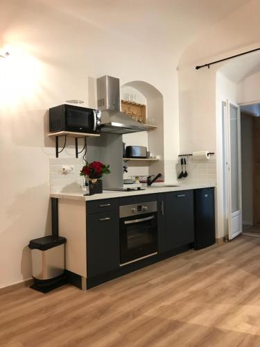 une cuisine avec un comptoir noir et blanc dans l'établissement Studio plein centre ville, à Ajaccio