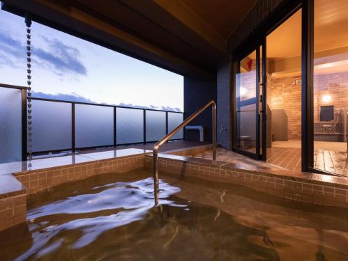 a hot tub in a house with a view at Central Hotel Takeoonsen Ekimae in Takeo