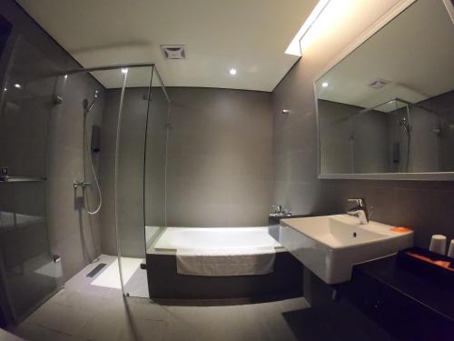 Hotel Orchard Park - New Wing في دايوان: حمام مع حوض ومغسلة ودش