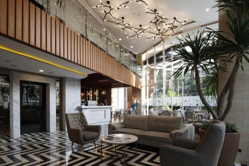 a lobby with a couch and chairs and a table at Verse Luxe Hotel Wahid Hasyim in Jakarta